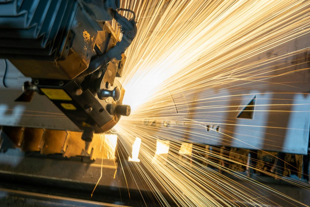 Photo by Clayton Cardinalli on Unsplash. Shows a robot cutting into metal, with sparks going everywhere. Shows the potential danger to humans of some jobs.